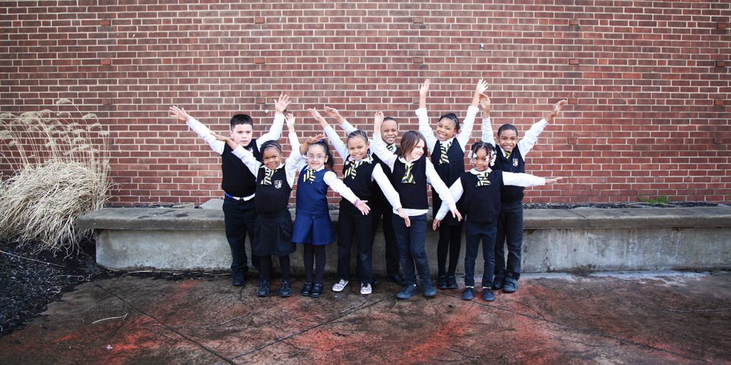 Students outside in a group smiling.