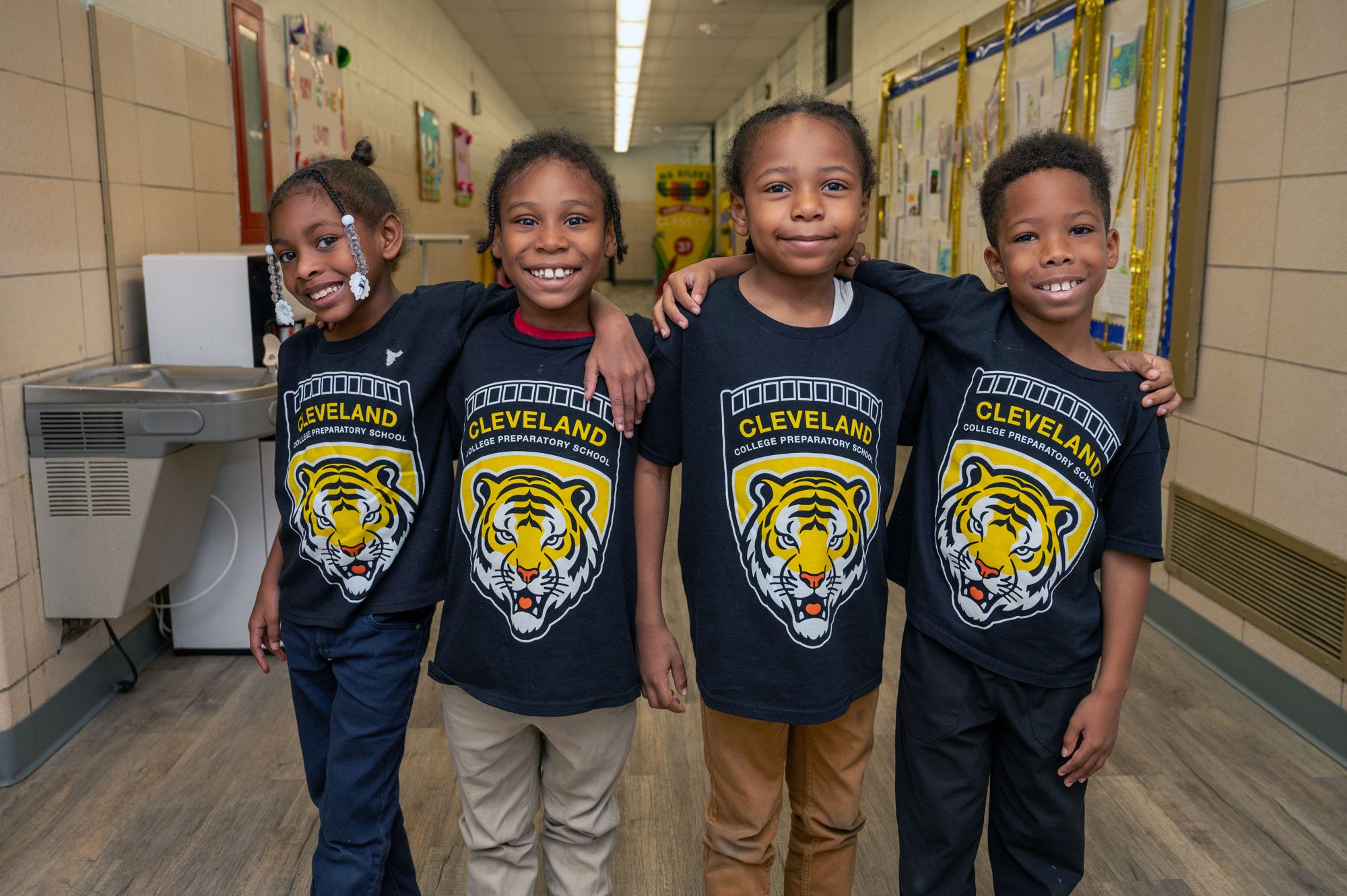 Group of students smiling and standing in hallway